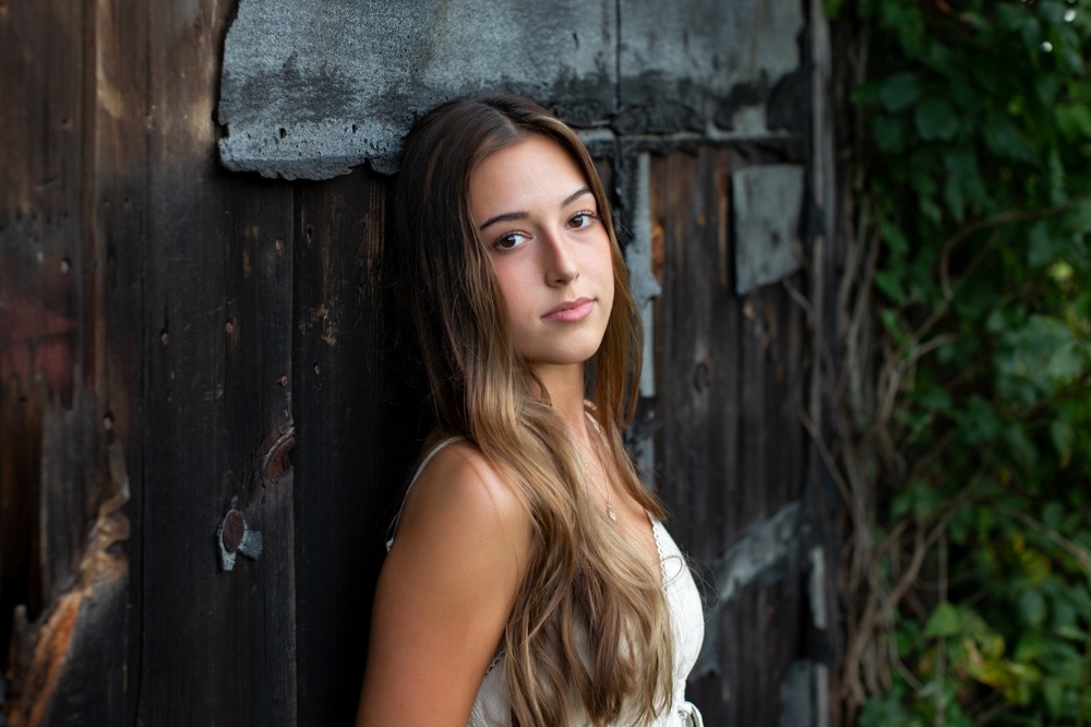 2021 ct senior portraits session leaning against old barn door at northwest park, ct 